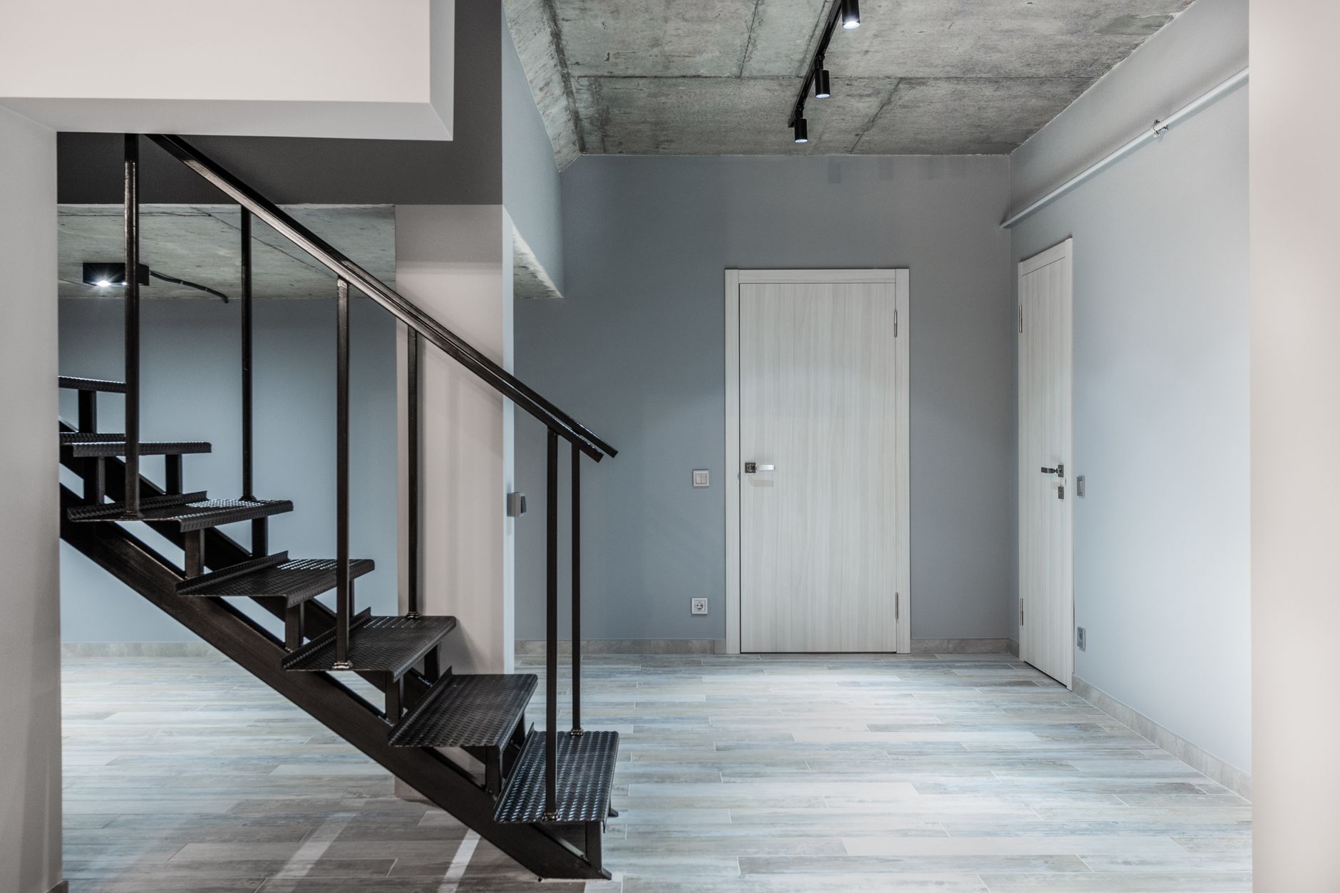 Black stairway and hallway with a smooth floor in a bright home