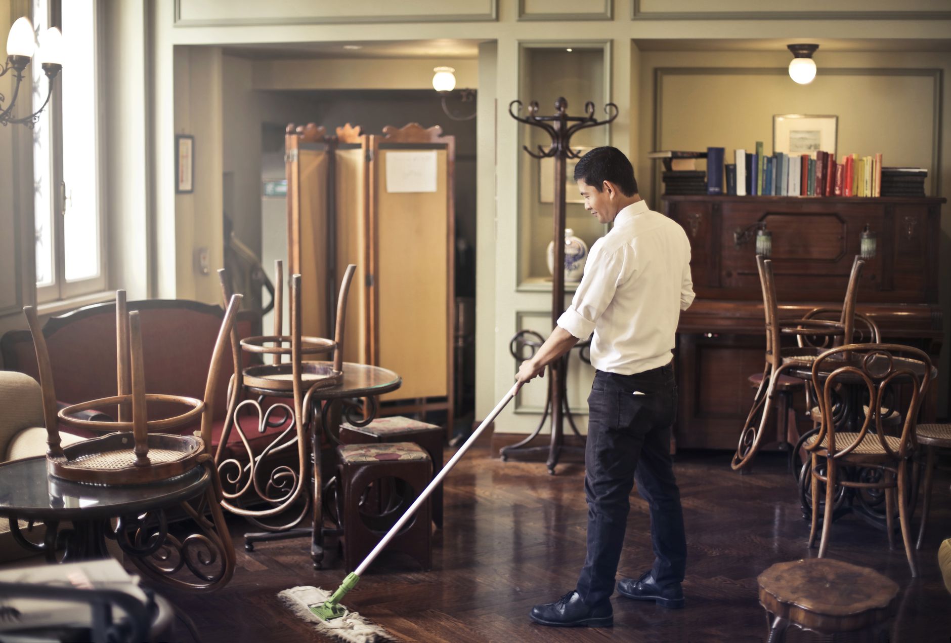 Worker in uniform cleaning a floor with a mop